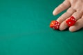 Man holds two red dices and throws them on green poker gaming table in casino. Concept of online gambling, winner or player Royalty Free Stock Photo