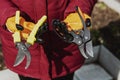 A man holds two secateurs of different kinds. The concept is the choice of tool for pruning shrubs Royalty Free Stock Photo