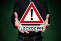 Man holds virtual warning sign that says Lockdown