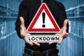 Man holds virtual warning sign that says Lockdown