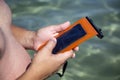 Man holds a waterproof case for phone