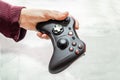 man holds wireless game controller in hand, gamepad for videogames. Hand demonstrates gamepad Royalty Free Stock Photo