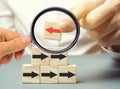 A man holds a wooden block with red arrow facing the opposite direction black arrows. Individual opinion. Stand out from the crowd