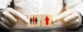 A man holds wooden blocks with the image of people and a red up arrow. The concept of population growth and mortality from