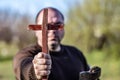 A man holds a wooden Christian cross in front of him, an ax in his other hand. The concept of casting out demons on Halloween Royalty Free Stock Photo