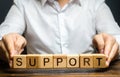 A man holds the word Support. Providing business assistance and support at all stages of startup development. State financial