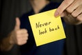 Man holds yellow sticker inscription Never look back