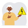 A man holds a yellow triangular warning sign with a black lightning in his hand. The concept of the danger of electric