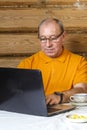 A man in a home office at a computer works next to a kettle and cups Royalty Free Stock Photo