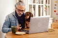 Man at home office with cute dachshund dog sitting close together Royalty Free Stock Photo