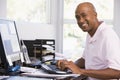Man in home office using computer and smiling Royalty Free Stock Photo