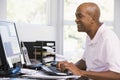 Man in home office using computer and smiling Royalty Free Stock Photo