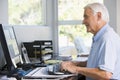 Man in home office using computer smiling Royalty Free Stock Photo