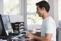 Man in home office using computer and smiling Royalty Free Stock Photo