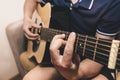 Man at home is playing the guitar. Guys hands are taking the chord on strings. Music making lifestyle concept. Free time hobby for Royalty Free Stock Photo