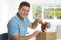 Portrait Of Man At Home Sealing Box For Dispatch Royalty Free Stock Photo