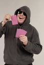 A man in a hood holds playing cards in his hands Royalty Free Stock Photo