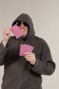 A man in a hood holds playing cards in his hands Royalty Free Stock Photo