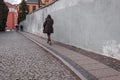 Man in a hooded black jacket walking on the street