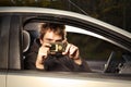 Man in hooded black shirt making photo of his victim with cell phone camera