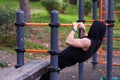 Man in hoodie doing pull-up exercise on bar outdoors Royalty Free Stock Photo