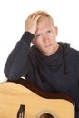Man in hoodie with guitar close stressed