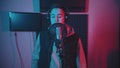 A man in hoodie rapping in the record studio gesticulates while recording his track