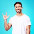 Man, horns and love in studio portrait with smile, kindness and sign language by blue background. Young guy, student and Royalty Free Stock Photo