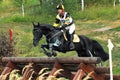 Man horsebak on jumping black chestnut horse