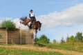 Man horsebak on jumping red chestnut horse