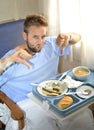 Man in hospital room eating healthy diet clinic food in upset moody face expression Royalty Free Stock Photo