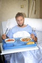 Man in hospital room eating healthy diet clinic food in upset moody face expression Royalty Free Stock Photo