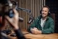 Man host talking to microphone and interviewing a man for a radio podcast. Royalty Free Stock Photo