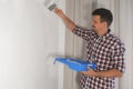 Man house painter is painting wall using brush doing renovation at home, DIY. Royalty Free Stock Photo