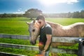 Man Hug White Horse On Rancho Farm At Sunny Summer Day.