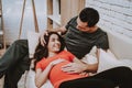 Husband and Pregnant Wife Relaxing on Couch Royalty Free Stock Photo