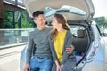 Man hugging a woman seated on an open car trunk Royalty Free Stock Photo