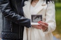 A man hugs his pregnant wife. Woman holding ultrasound photo of baby near belly Royalty Free Stock Photo