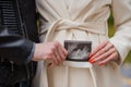 A man hugs his pregnant wife. Woman holding ultrasound photo of baby near belly Royalty Free Stock Photo