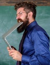 Man hungry for knowledge. He needs new information. Thirst of knowledge. Teacher bearded man bites modern laptop Royalty Free Stock Photo