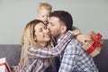 Man husband gives a gift of flowers to a woman hugs congratulates indoors