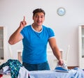 Man husband ironing at home helping his wife Royalty Free Stock Photo