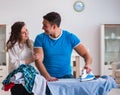 Man husband ironing at home helping his wife Royalty Free Stock Photo