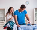 Man husband ironing at home helping his wife Royalty Free Stock Photo