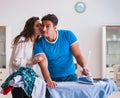 Man husband ironing at home helping his wife Royalty Free Stock Photo