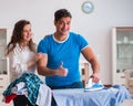 Man husband ironing at home helping his wife Royalty Free Stock Photo