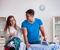 Man husband ironing at home helping his wife Royalty Free Stock Photo