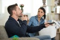 man hushing wife while watching television Royalty Free Stock Photo
