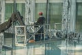 A man on a hydraulic platform checking glass faÃÂ§ade of a corporate building