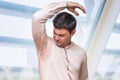 Man with hyperhidrosis sweating under armpit in office Royalty Free Stock Photo